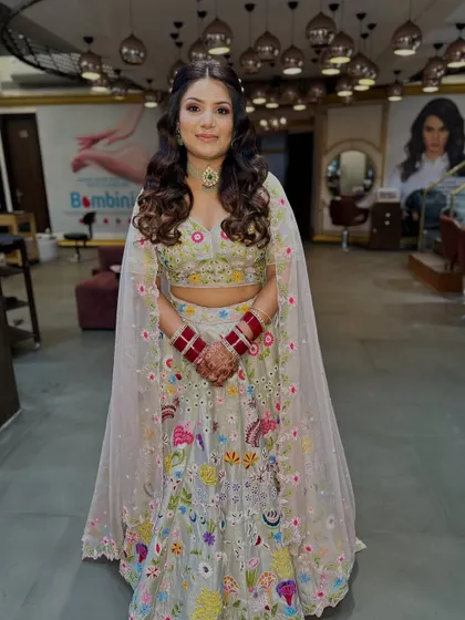 A full-length view of this stunning floral lehenga look. The makeup and hair are styled to create a cohesive and effortlessly beautiful appearance.