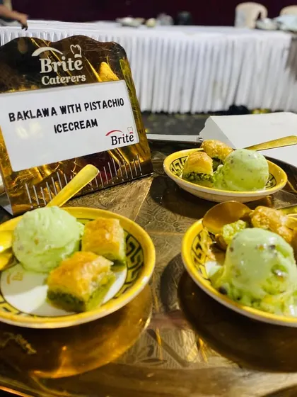 Servings of Baklava with Pistachio Ice Cream on a golden tray.
