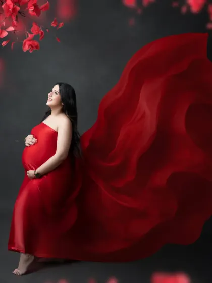 The beauty of anticipation captured in a swirl of red. The flowing fabric of the gown adds a dynamic and artistic element to this classic maternity pose.