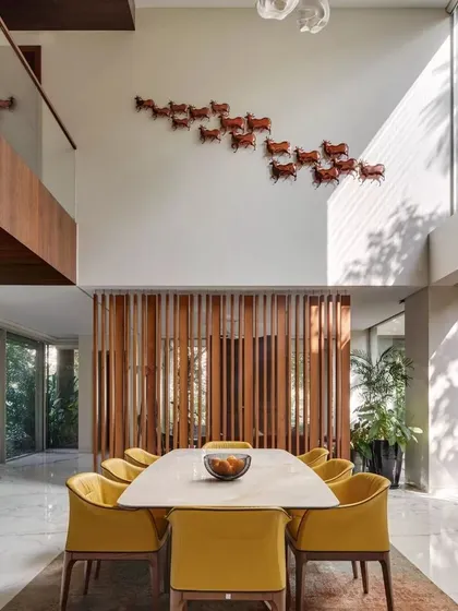 The grand dining space at Kanasu, filled with daylight from floor-to-ceiling windows that open up to the garden.