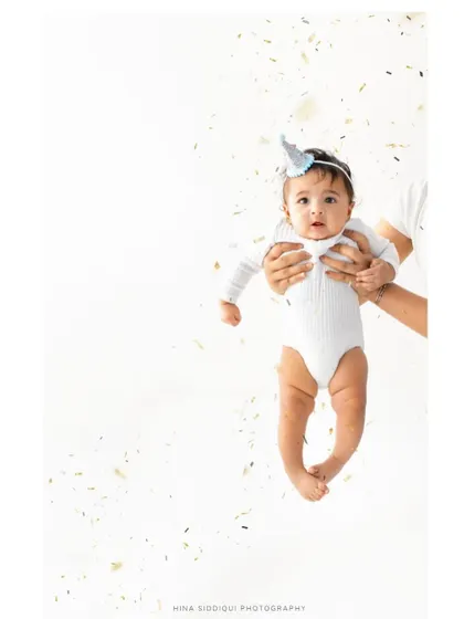 A full portrait version of the confetti celebration. Being held securely in loving hands while looking at the camera creates a feeling of safety and joy.