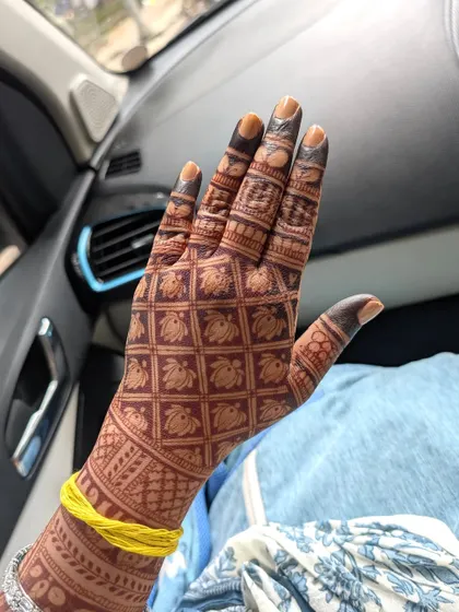 The gorgeous, deep red stain of Ananya's wedding mehendi, featuring a grid of lotus motifs.