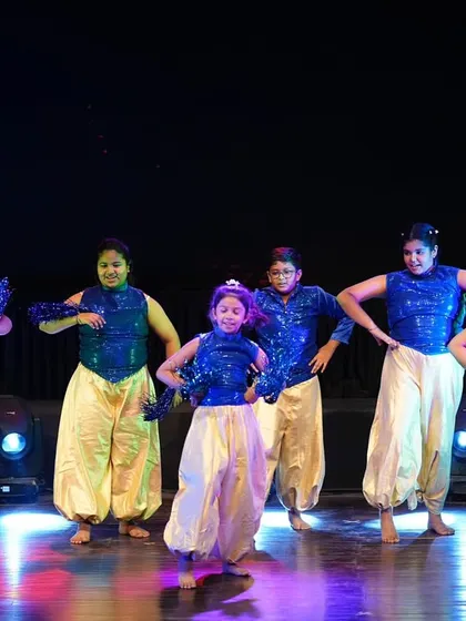 The girls striking a confident pose in their coordinated Bollywood costumes. We teach them to perform with attitude and stage presence.