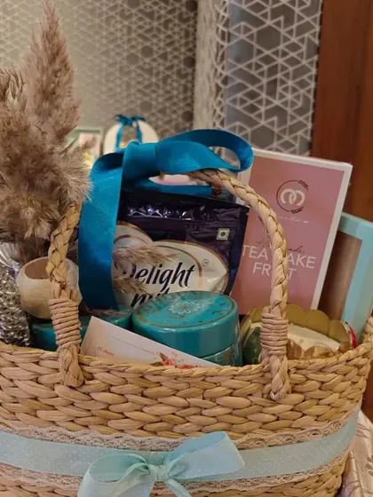 This special edition Diwali hamper is presented in a handwoven basket. It's filled with a mix of gourmet snacks and lifestyle items, and decorated with pampas grass for a rustic, elegant look.