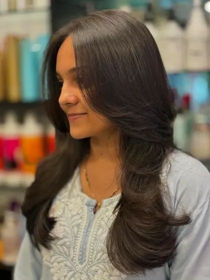 This client's new layered cut gives her hair a healthy, full-bodied look. The layers are cut to enhance the natural texture and create a soft, flowing silhouette.