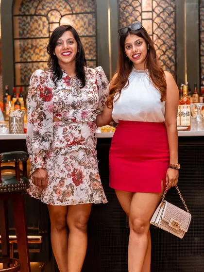 Two guests posing by the bar. The classic and elegant bar area serves as a popular spot for photos and socializing during events.