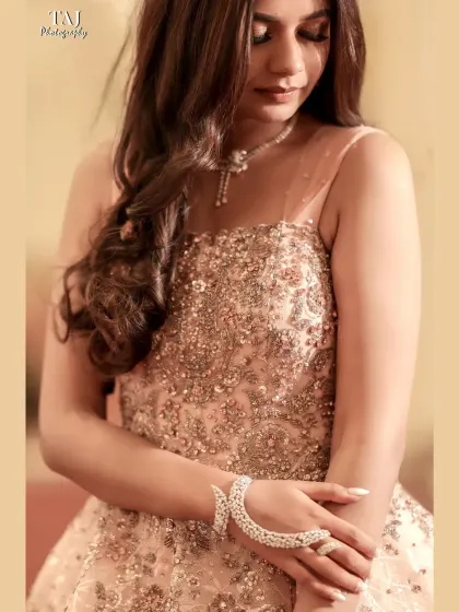 A close-up shot focusing on the stunning details of the bride's gown and her elegant hand jewelry. This type of shot is perfect for capturing the beauty of a bridal look.