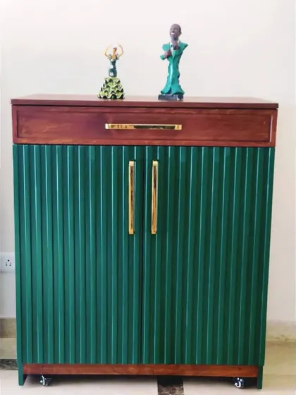 A striking bar cabinet with a fluted green facade and a contrasting wood top. The castor wheels make it a flexible piece for entertaining.