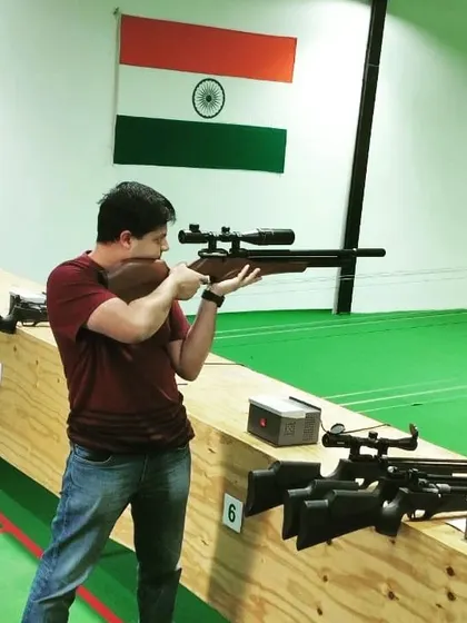 This shooter is using an air rifle equipped with a scope. While not used in 10-meter competitions, it's a fun way to practice precision aiming.