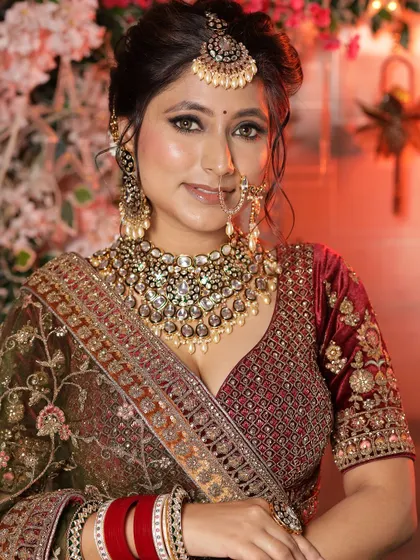 A smiling bride in her full glory, wearing our velvet lehenga and heavy jewellery set.
