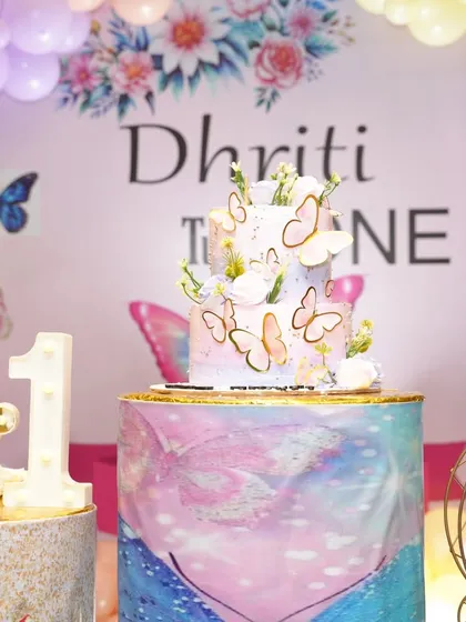 A close-up of a two-tiered butterfly-themed cake, showing the delicate details.