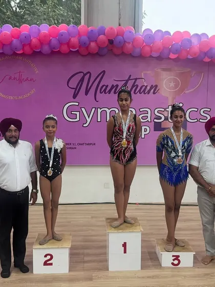 Standing proud on the winner's podium. We coach our gymnasts not just to perform, but to win, and moments like these at the Manthan Gymnastics Cup are what it's all about.
