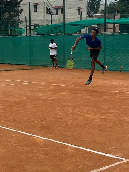 A player airborne during a jump serve. This advanced technique requires exceptional timing and athleticism, which we develop through specialized drills.