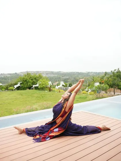 Hanumanasana, or the full front splits, practiced in a saree by the pool. This pose is a testament to patience and consistent practice, as it requires very open hamstrings and hip flexors.