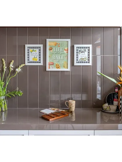 A close-up of the kitchen counter, featuring charming, framed art against a tiled backsplash. We believe in adding personal touches to make every corner of the home feel special.