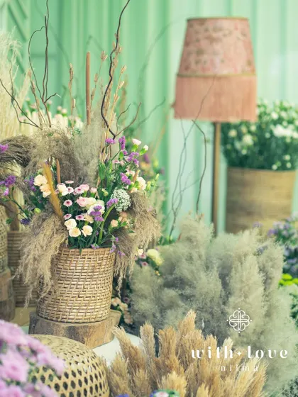 A corner of 'The Conservatory' filled with wicker baskets of dried grasses and flowers, adding texture and a rustic touch to the modern design.