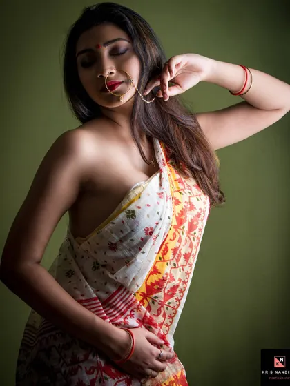 A serene portrait from the 'Moksha' series. The model, draped in a saree, has her eyes closed, conveying a sense of peace and inner release against a soft green background.