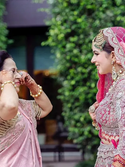 The mother of the bride shows off her own mehandi design while sharing a special moment with her daughter. We create designs for all generations.
