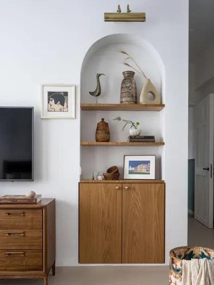 An arched niche in the 'Inde Blue' project, filled with curated objects. Every choice in this home, from the curve of a doorway to the handmade imperfection of surfaces, was born out of a desire to create a space that feels deeply personal.