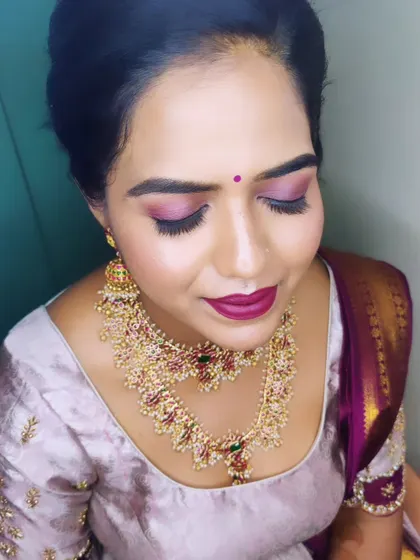 A close-up of Manasa's makeup for her pre-wedding rituals. The focus is on the bold, shimmery purple eyeshadow and a matching deep lipstick.