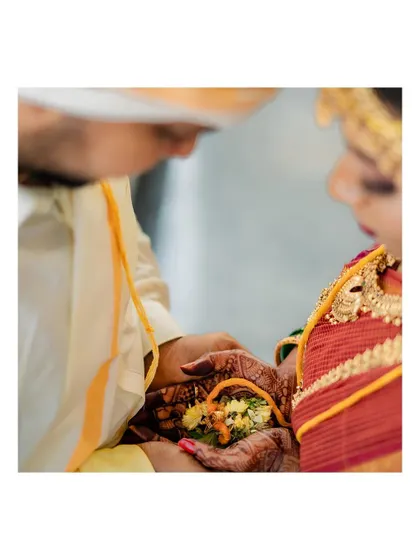A close-up of the couple's hands during a traditional wedding ritual.