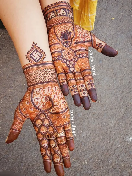 A design rich with auspicious symbols, including a swastika, elephants, and lotus flowers, perfect for a traditional wedding.