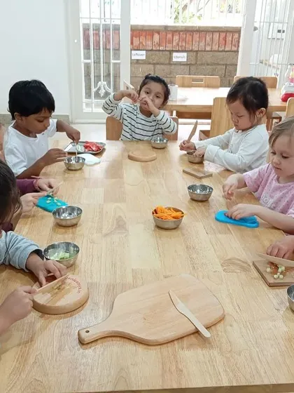 Our preschoolers practice their chopping skills with child-safe wooden knives and play vegetables, preparing a "salad."
