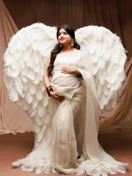 A fusion of the divine and the traditional. Combining ethereal angel wings with the grace of a saree, we create a powerful portrait of the guardian angel a mother is to her child.