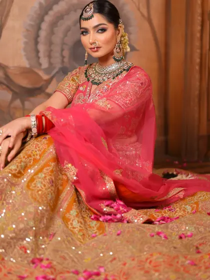 The bride seated amidst a bed of rose petals, looking like a true queen. The full lehenga is on display, and her makeup remains the focal point of her regal look.