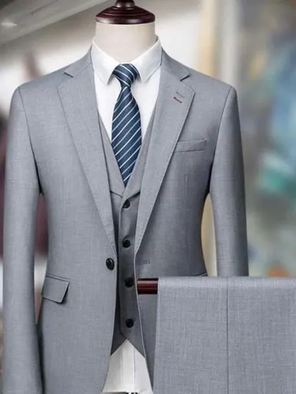 A three-piece suit in a light grey, showing the complete set with trousers. It's a timeless and elegant option.