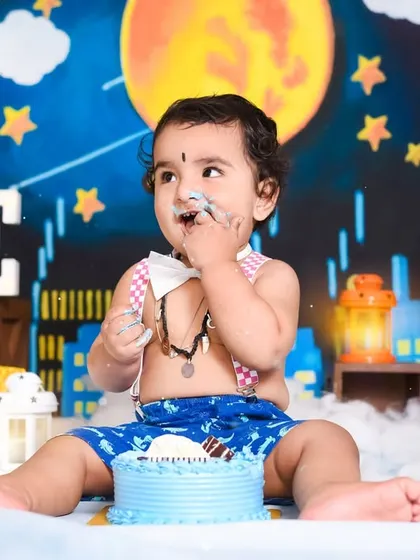 A full view of the superhero-themed cake smash setup, complete with a cityscape background and the 'ONE' sign to mark this special first birthday.