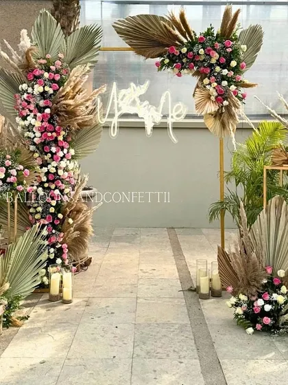 A full view of a stunning rooftop proposal setup. I used a mix of fresh pink and white roses, dried palm leaves, and pampas grass to create a modern, romantic, and texturally rich floral arch.