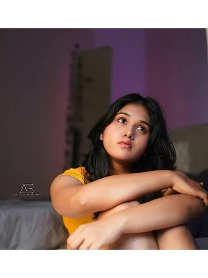 A pensive moment from the same indoor shoot. Her upward gaze and the soft lighting create a feeling of introspection and day-dreaming.