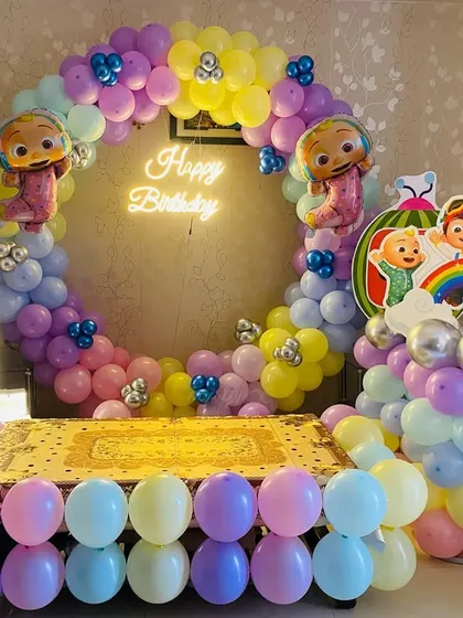 A Cocomelon themed first birthday party with a full balloon ring and a cake table setup. The pastel colors and character cutouts make it perfect for a toddler's party.
