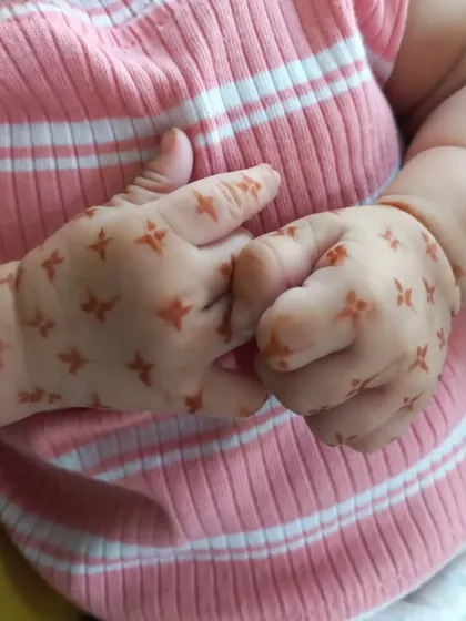 How sweet are these little hands? I applied a simple pattern of tiny four-petaled flowers, which is a great option for very young children who can't sit still for long.