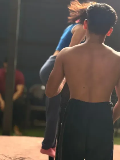 A coach providing support during a bar exercise. This allows the athlete to build confidence and strength.