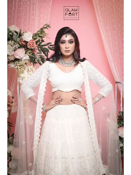 A powerful, confident pose. The contrast between the all-white outfit and the dark, intense eye makeup makes a bold statement.