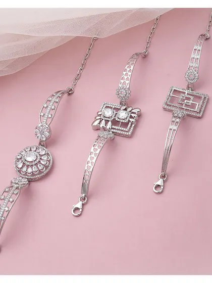 A collection of three distinct silver bracelets. Each piece features a unique central charm and link design, showcasing the variety and style of our collection.