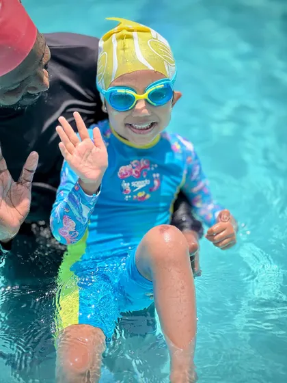 A friendly wave from the pool. Our coaches build a great rapport with the kids, making swim class something they look forward to.