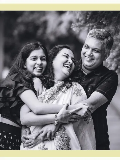 A candid black and white portrait of a family sharing a genuine, heartfelt laugh. This is the essence of our lifestyle photography approach, capturing the real connections and happy moments.