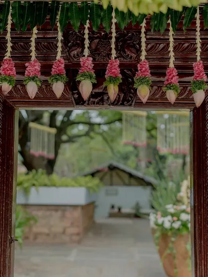 Doorway decor with hanging lotus buds and mango leaves, traditional and auspicious.