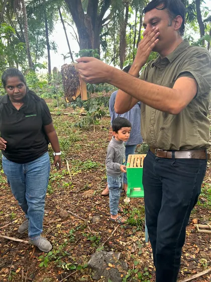 An adult participant smells a part of the beehive, engaging his senses to learn more about the bees' world.
