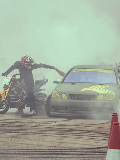 A stunt rider and a drift car create a massive cloud of smoke, a signature moment of our stunt shows. The smell of burning rubber is the smell of excitement.