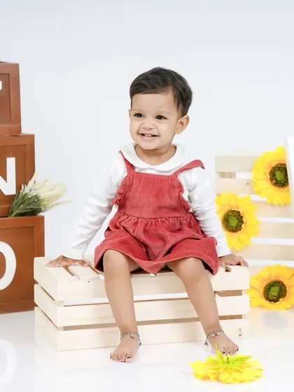 A happy and relaxed pose from a second birthday shoot. The combination of wooden crates and sunflowers creates a rustic, cheerful vibe.