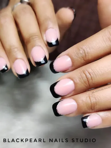 A bold and edgy take on the French manicure, featuring black tips with a subtle silver chrome line. This design is perfect for clients who want a classic style with a modern, dramatic twist.