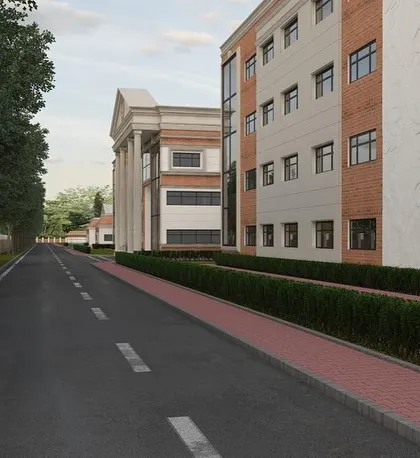 A view down the road alongside the school. This shot emphasizes the scale of the project and how the architectural design fits into its surrounding landscape.