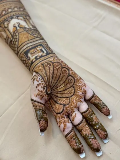 Another angle of the peacock feather mehandi, highlighting the beautiful floral patterns on the fingers and the detailed work on the arm.