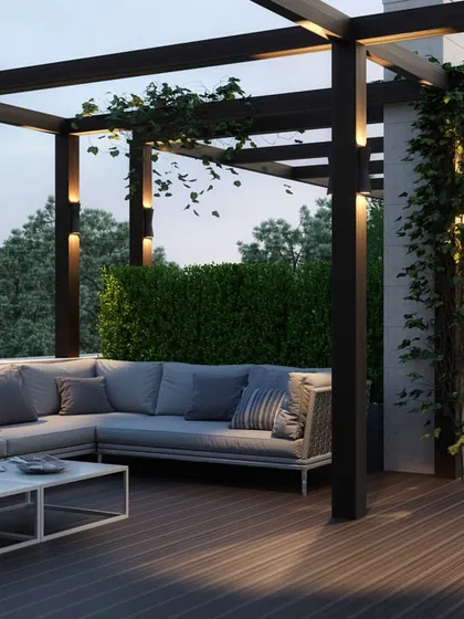 A spacious rooftop lounge area with a large L-shaped sofa under a modern pergola, ideal for entertaining guests outdoors.