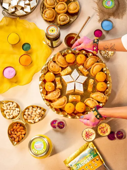 Another angle of the Holi flatlay, offering a different composition of the sweets, colors, and brand products.