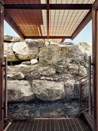 The entrance to one of our hillside homes, showcasing the use of industrial materials like steel mesh for stairs and ceilings. This creates a modern, durable aesthetic that complements the natural rock formations.